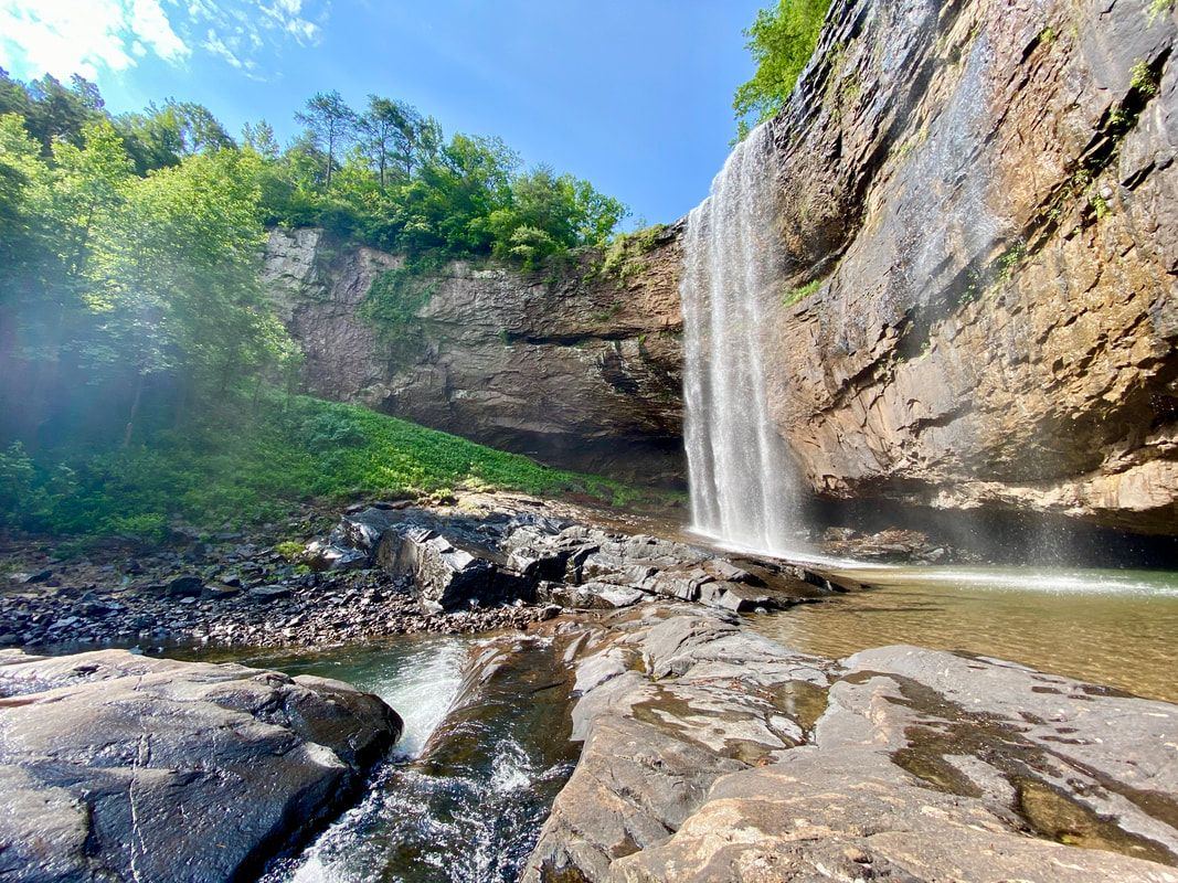 A waterfall pouring off a rock bluff into a pool at Lula Lake