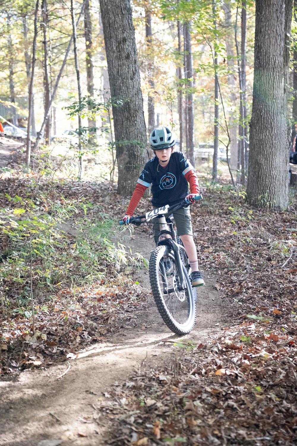 A young racer riding through the woods