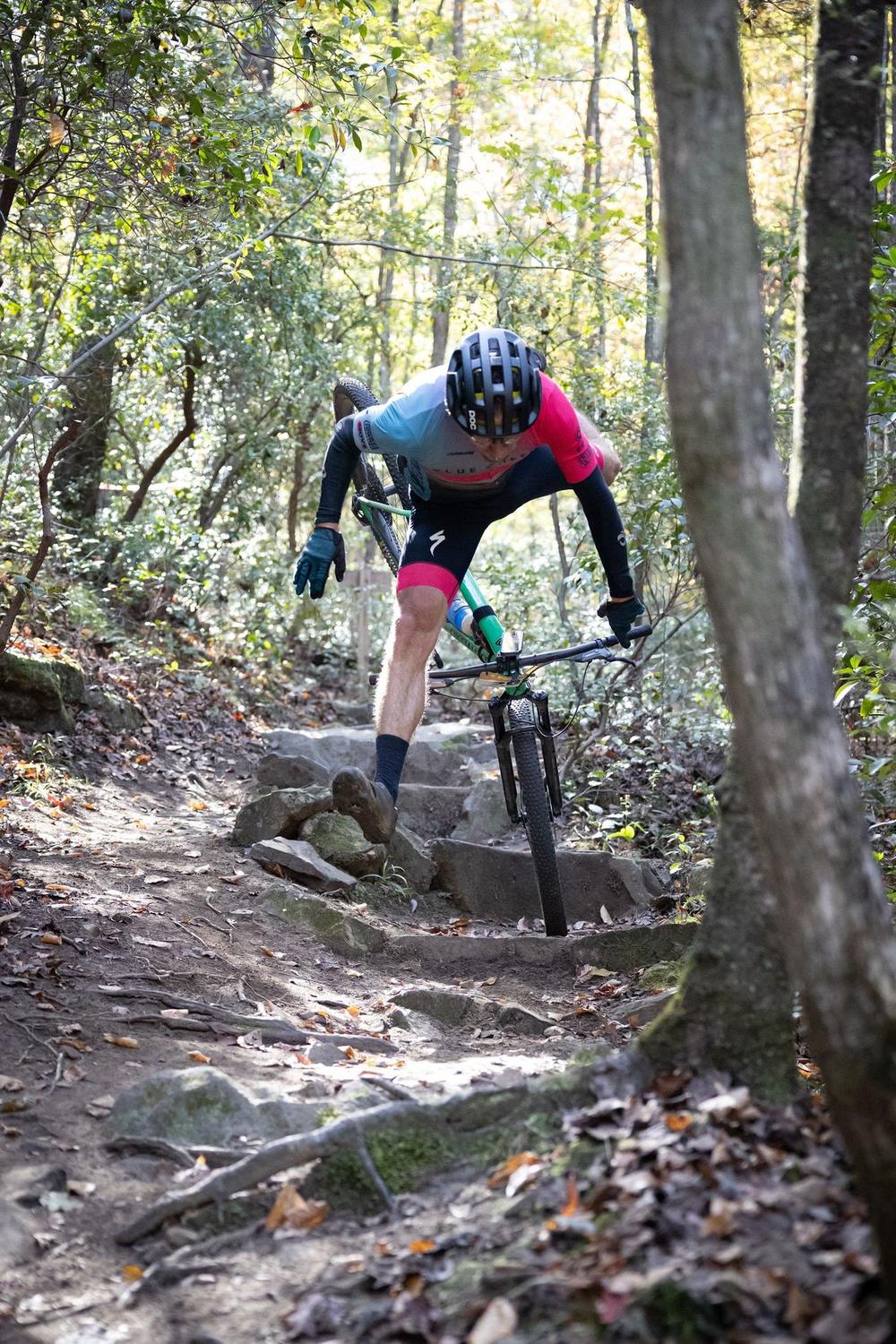 Racer riding rocky singletrack in the woods