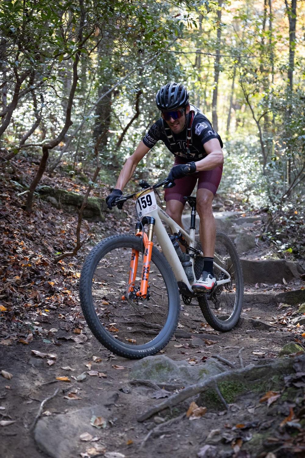 Racer riding rocky singletrack in the woods